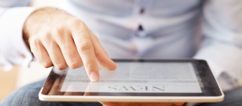 a man looking at news on a tablet